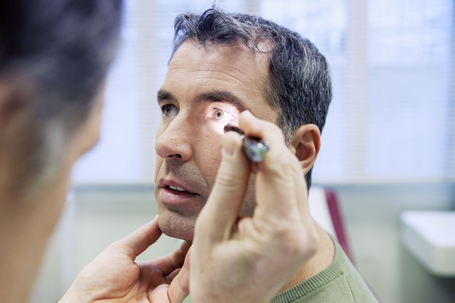 A man is getting his eyes examined by a doctor.