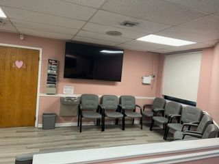 A waiting room with chairs and a flat screen tv.