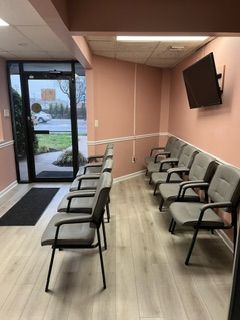 A waiting room with chairs and a television on the wall.