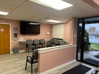 A waiting room with chairs and a flat screen tv.
