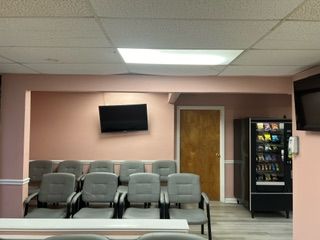 A waiting room with chairs and a vending machine