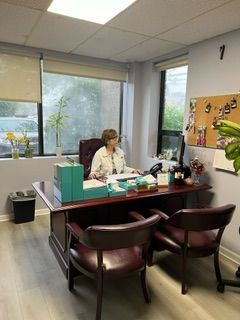 A woman is sitting at a desk in an office.