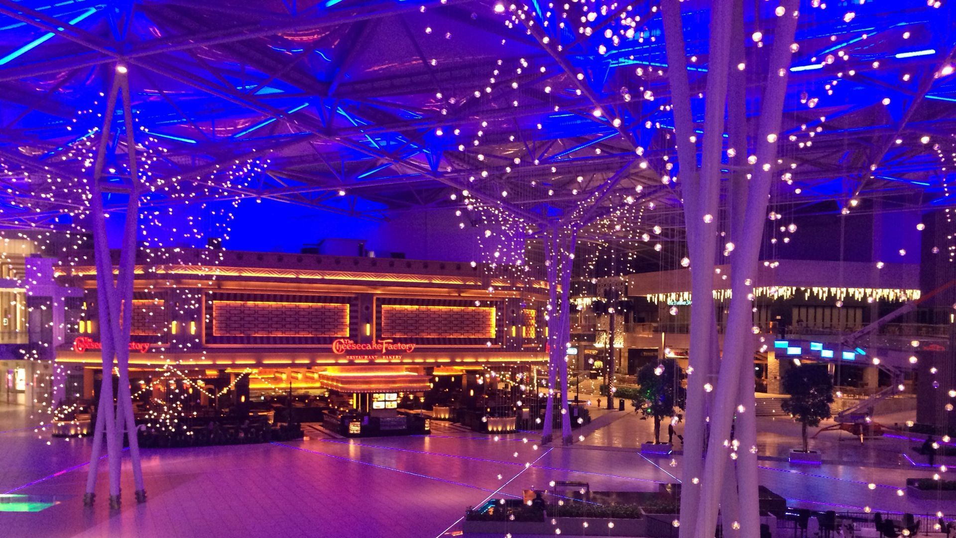 An illuminated interior with blue and purple lights, likely a shopping mall or event space.