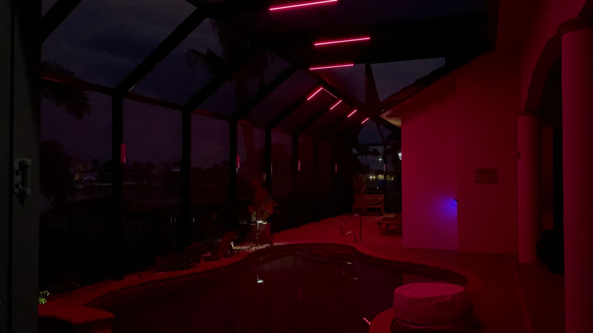 Indoor swimming pool area with pink neon lights.