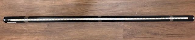 Black and silver object on a wood surface.