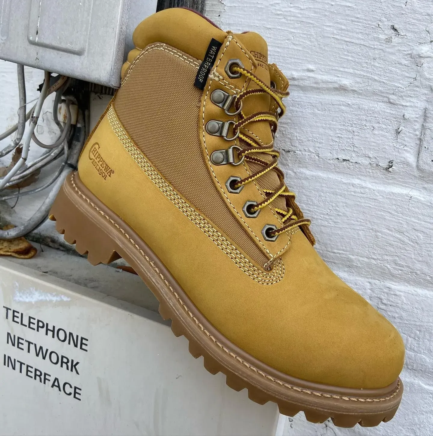 Yellow work boot with tan laces and sole, sitting on a box labeled