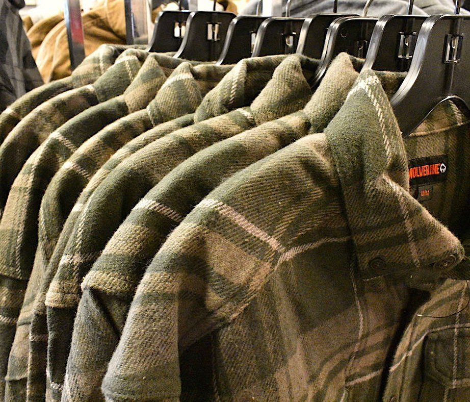 Green plaid shirts hanging on a rack in a store.