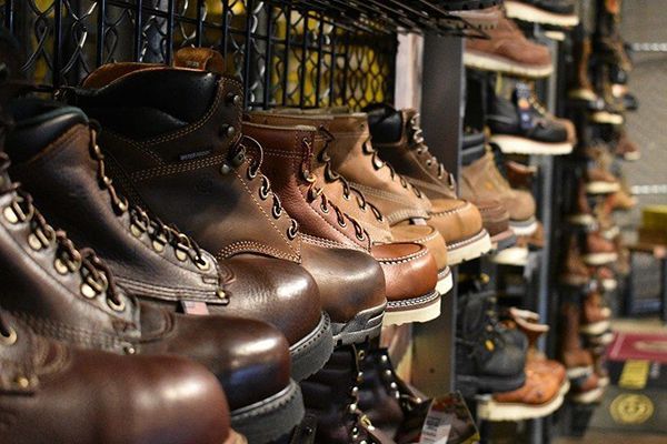 Person wearing dark blue hiking boots in a forest setting.