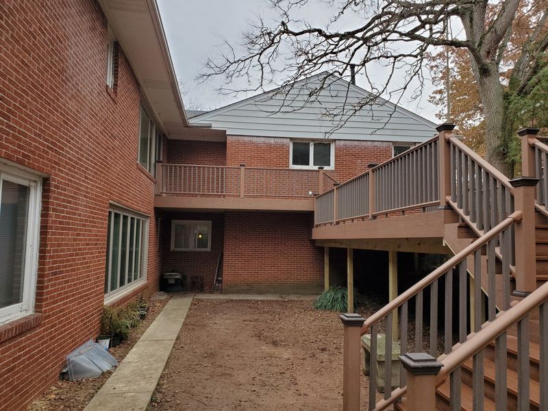Brick buildings with brown decks and stairs. Overcast day.