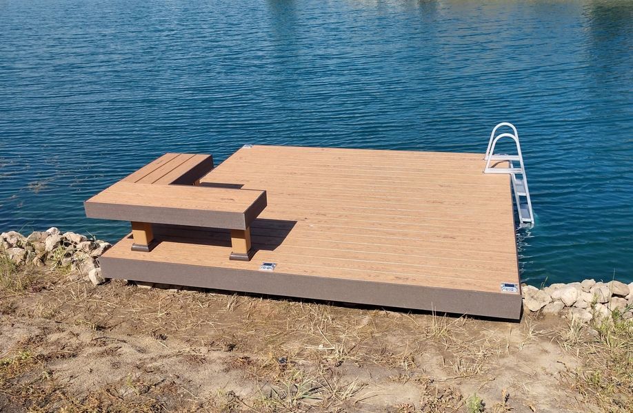 Dock with bench and ladder on water's edge, brown and blue tones.