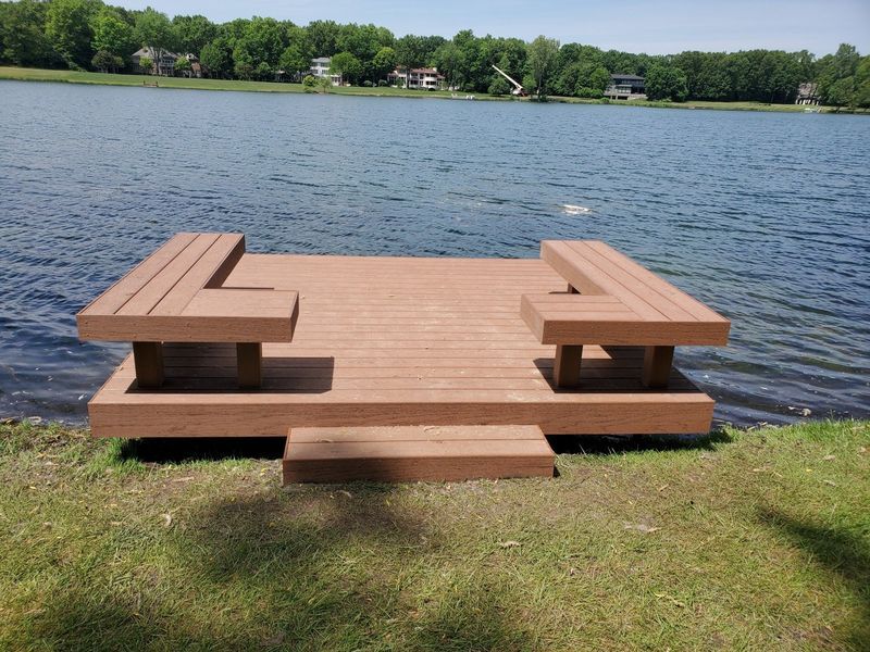 Wooden dock with built-in benches extending into a lake.