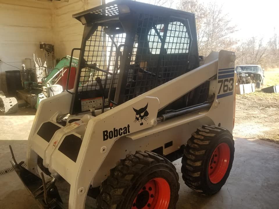 A bobcat skid steer is parked in a garage.