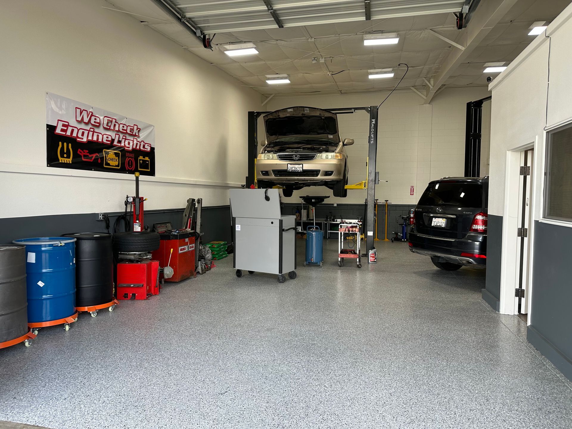 A car is sitting on a lift in a garage.