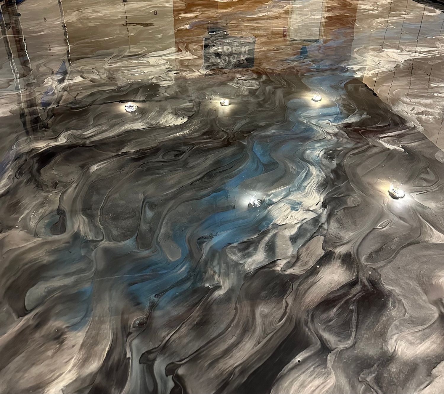 A close up of a black , white and blue epoxy floor.