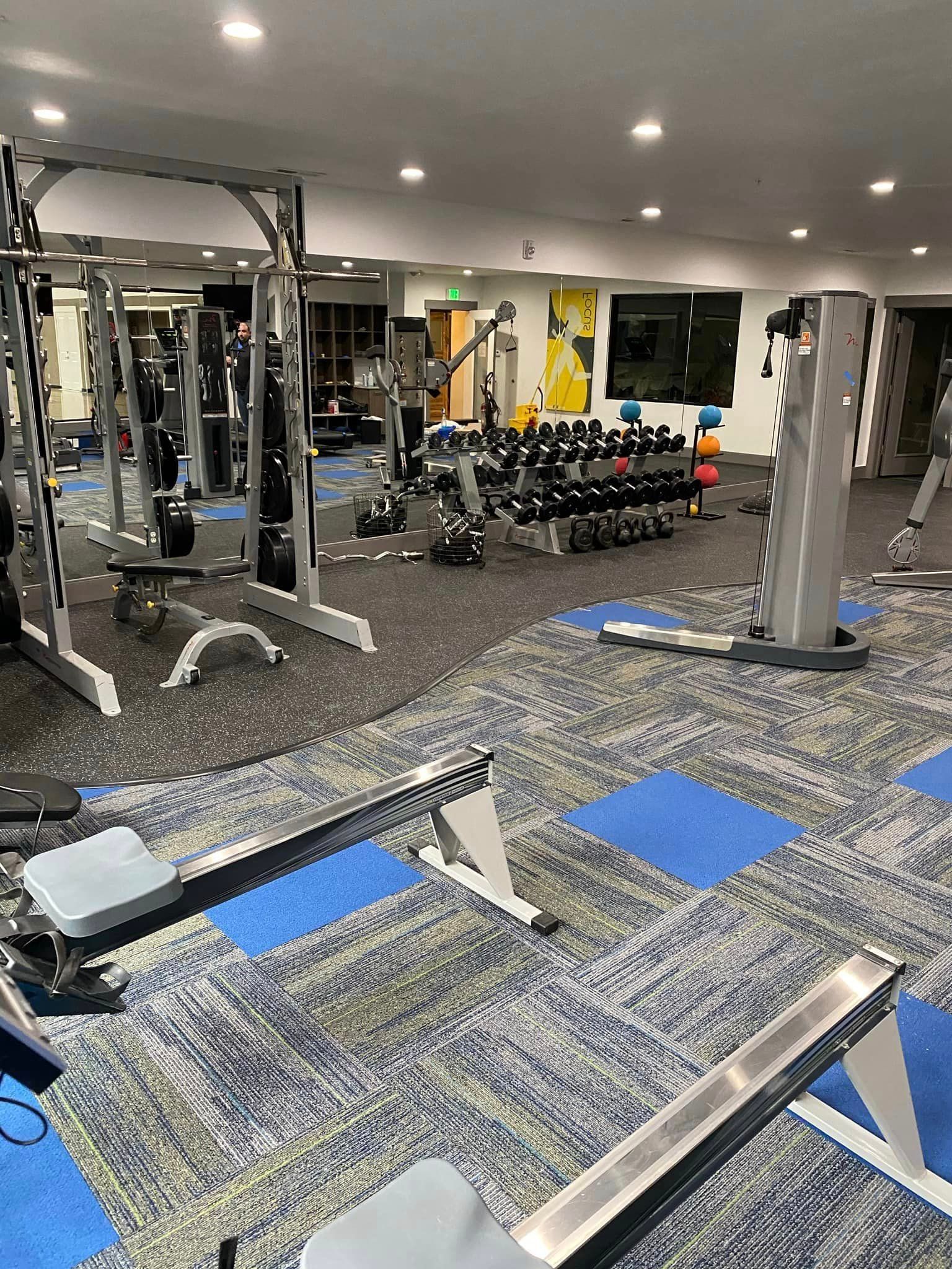 A large gym filled with lots of exercise equipment.
