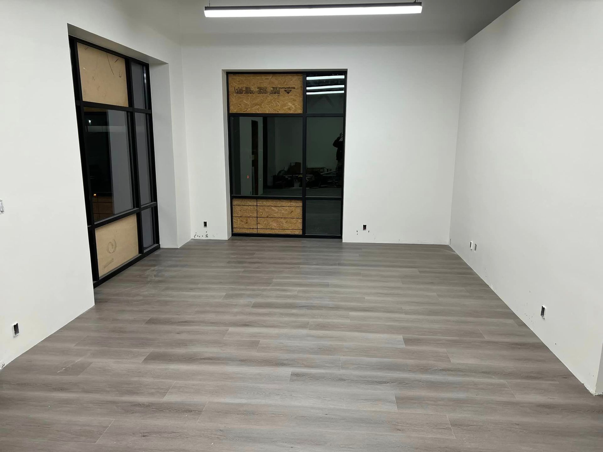 An empty room with a wooden floor and white walls