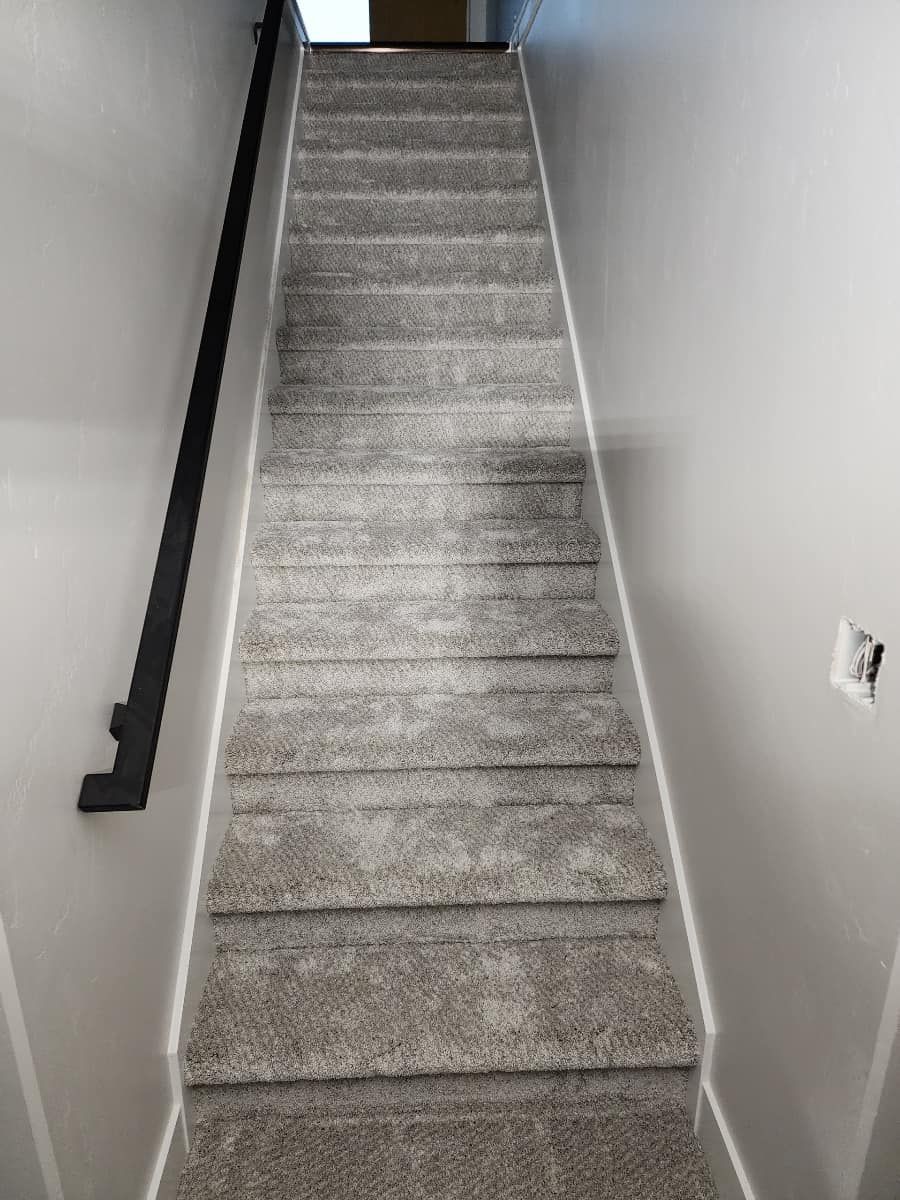 The stairs are carpeted and have a black railing.