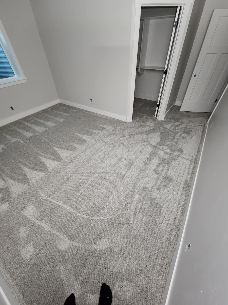 A person is standing on a carpeted floor in a bedroom.