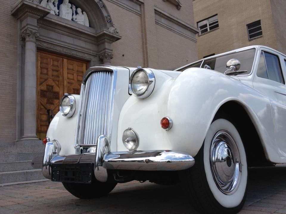 a white car is parked in front of a building
