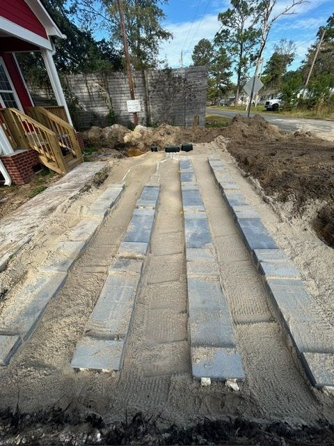 A concrete walkway is being built in front of a house.