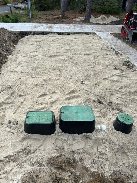 A sandbox with three green boxes in the sand.