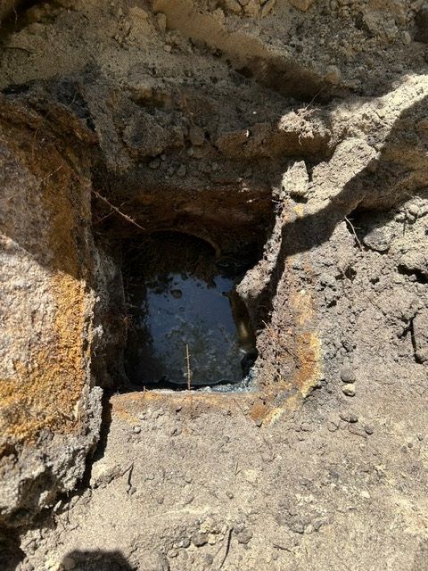 A hole in the ground with water coming out of it.