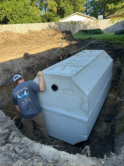 A man is standing next to a large concrete container in a hole.