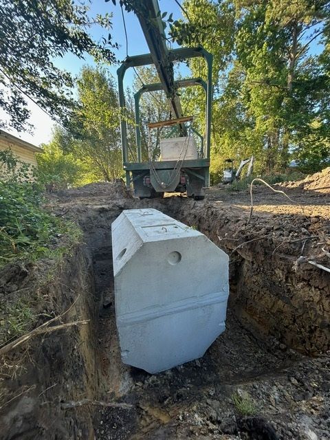 A large concrete block is being lifted by a crane.