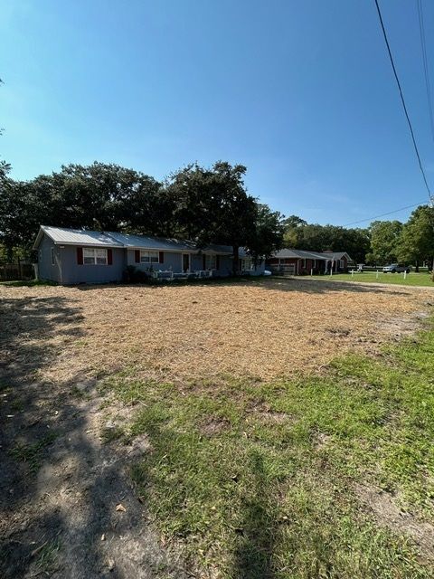 A house is sitting in the middle of a grassy field.