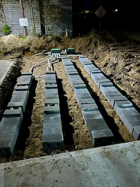 A row of concrete blocks are lined up in the dirt