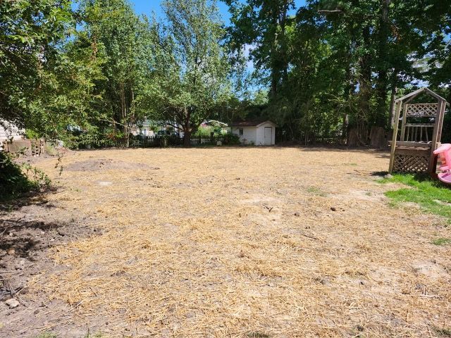 There is a pink swing in the middle of the yard.