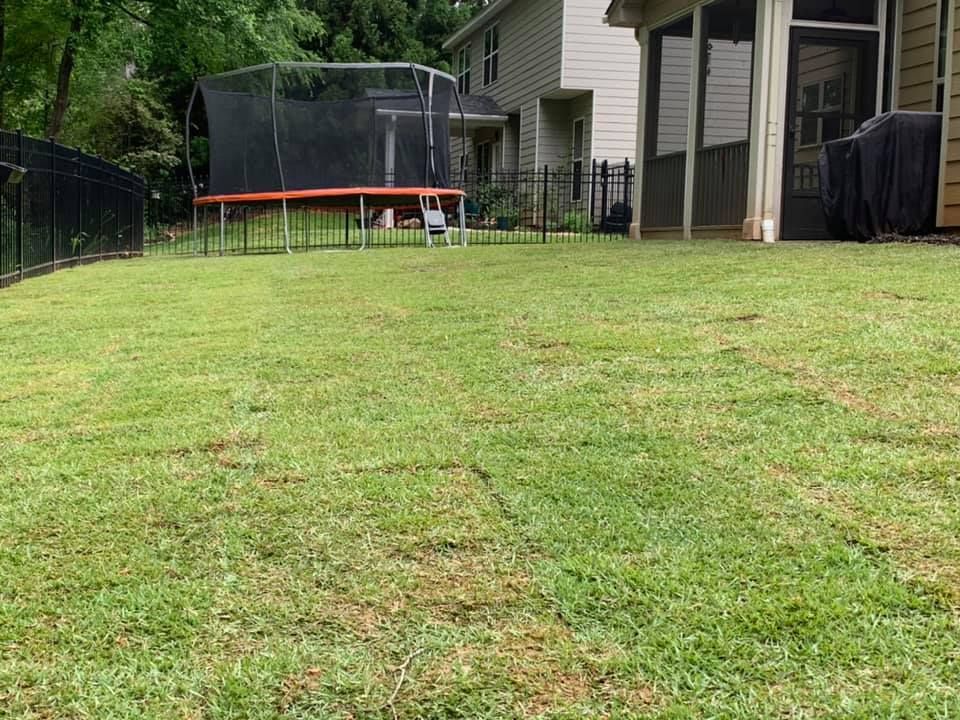 There is a trampoline in the backyard of a house.