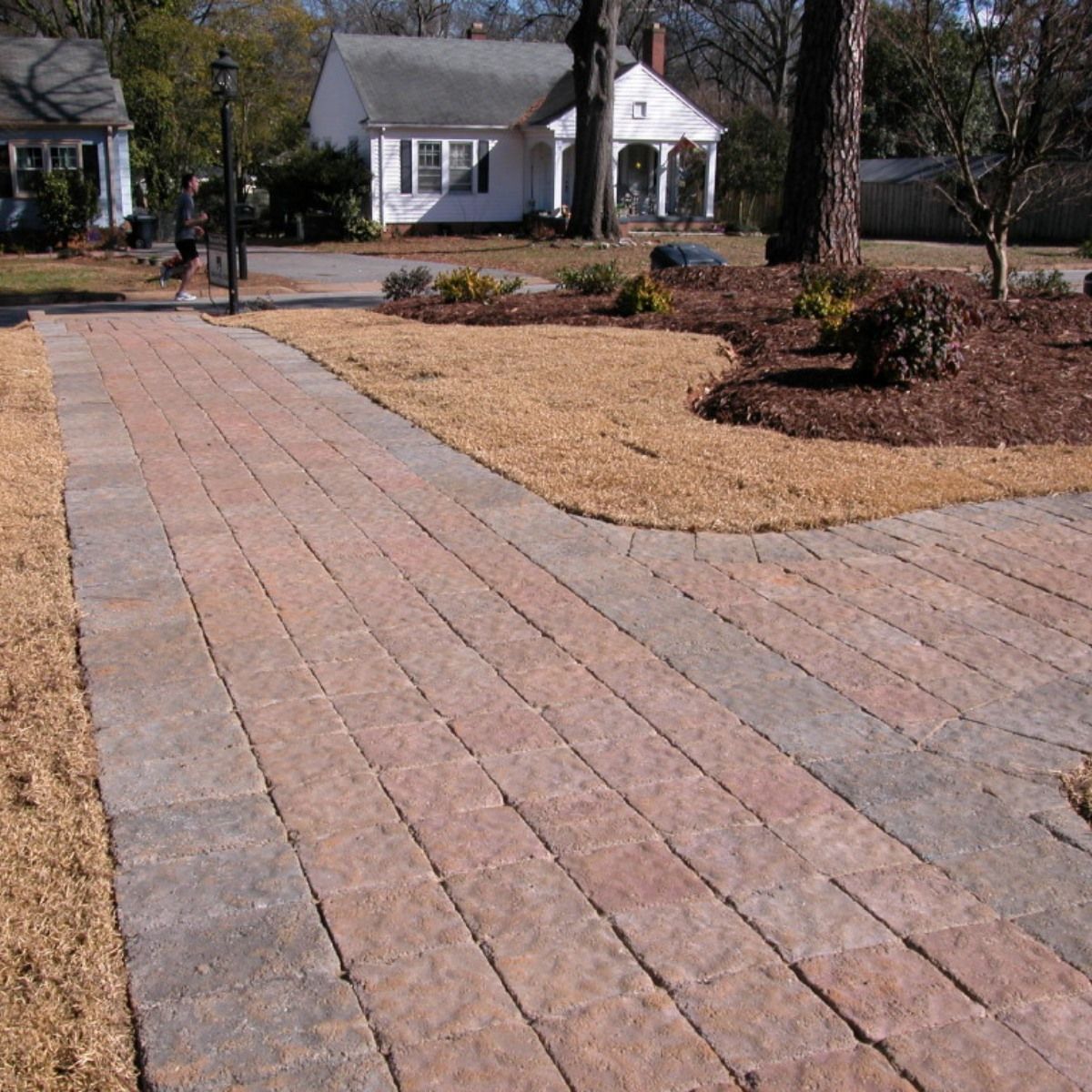 A brick walkway leads to a white house