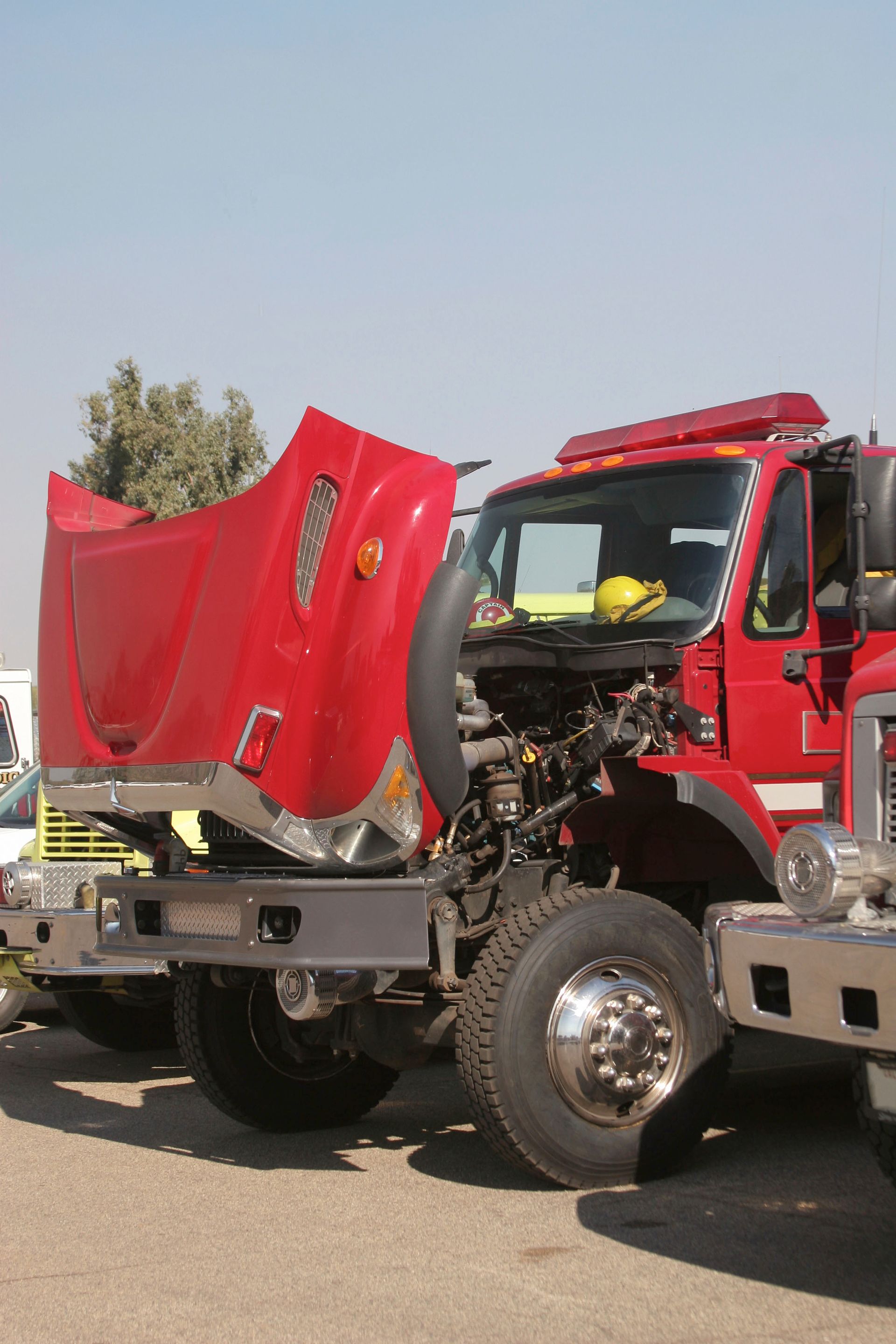 Red semi truck with crushed front end parked outdoors in daylight