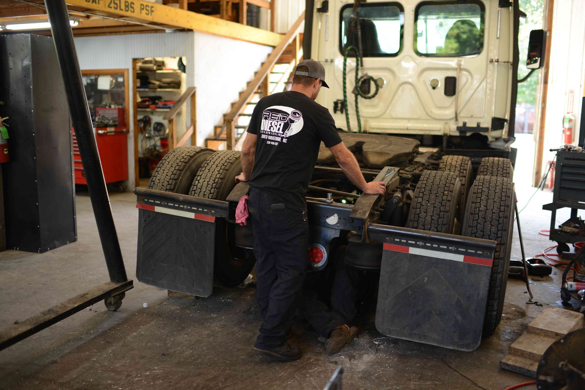 Mechanic inspecting a car tire inside an auto shop garage