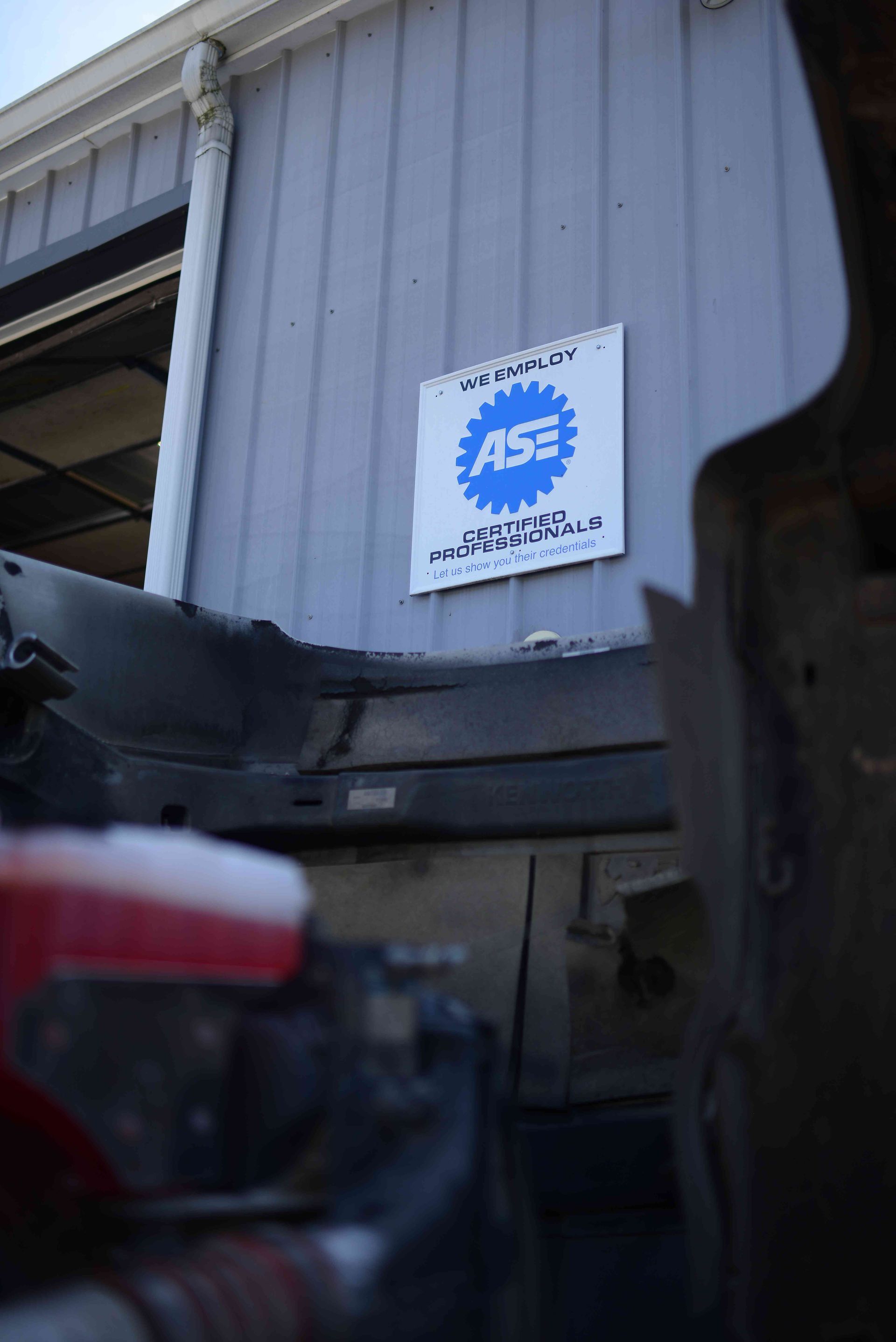 Blue APS logo sign mounted on a gray corrugated metal wall near a doorway.