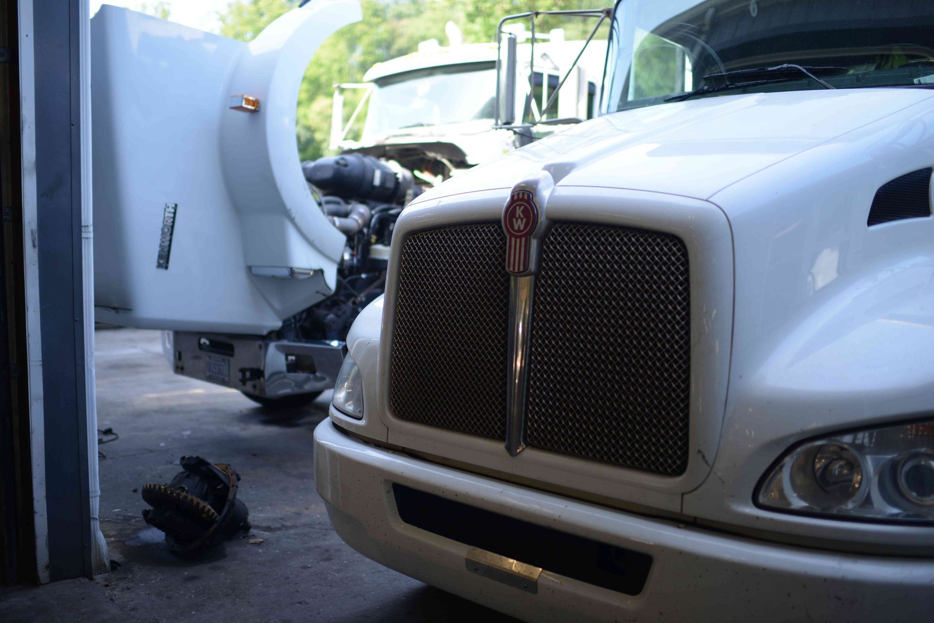 White truck and garbage truck in a close roadside collision scene