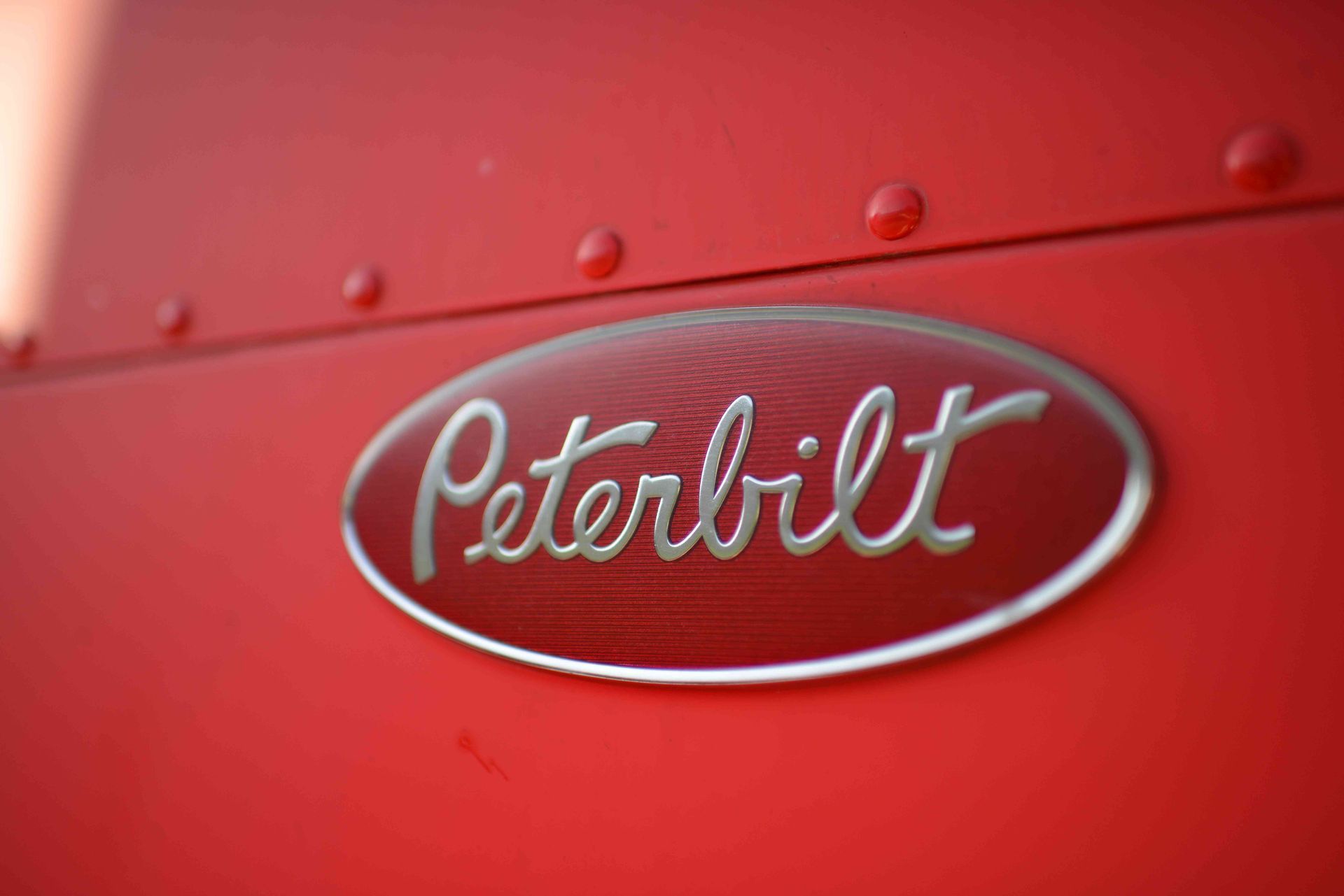 Red Peterbilt truck emblem on a glossy red surface