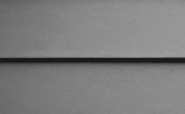 Gray surface with a dark horizontal line, possibly a seam or a shadow.