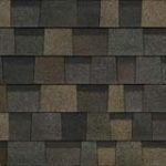 Close-up of a roof with overlapping asphalt shingles in shades of brown and gray.