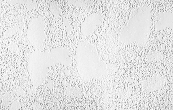 White textured wall with large, smooth, abstract shapes.