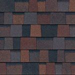 Close-up of asphalt shingles in shades of brown, red, and gray, creating a textured roof surface.