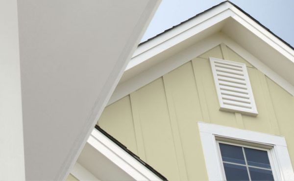 Light yellow house with white trim, window, and vent; partial view.