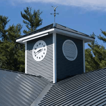 Clock tower with gray siding, white trim, and a weathervane on a metal roof.