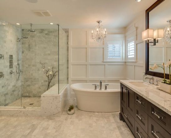 Elegant white bathroom with a shower, tub, and vanity.