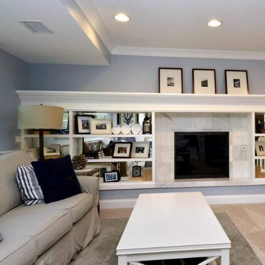 Living room with a white built-in entertainment center, TV, couch, and coffee table.