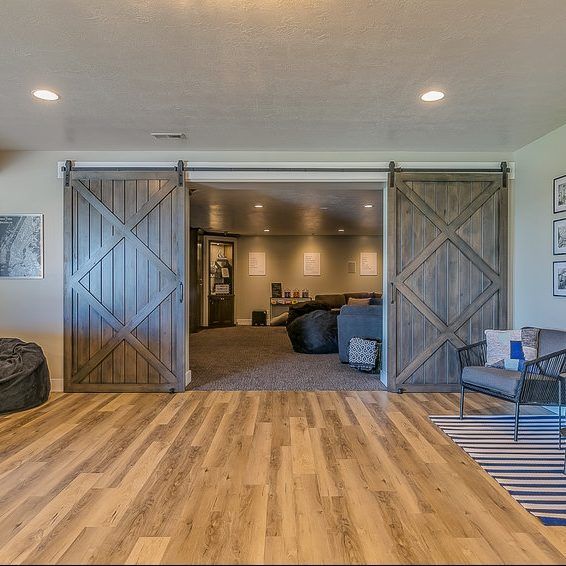Barn door entrance to a cozy rec room with wood floors, bean bags, and seating.