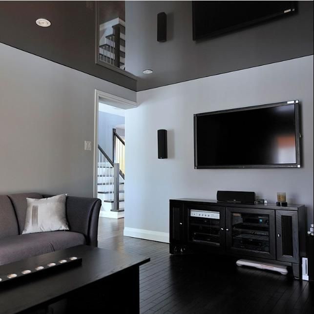 Living room with gray walls, black entertainment center, and TV; a gray sofa and black coffee table.
