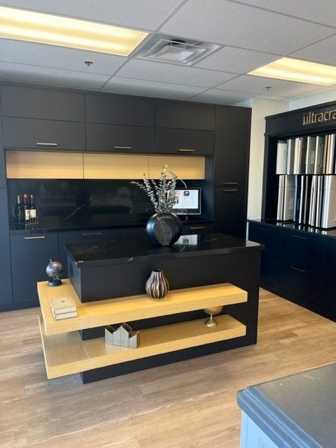 A kitchen with black cabinets and a large island