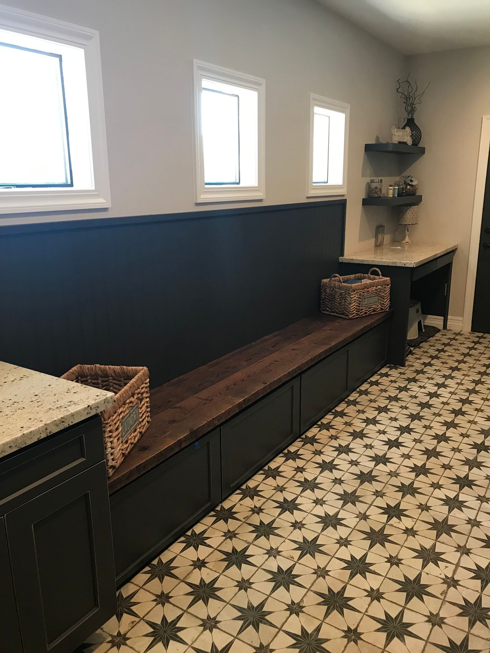 A laundry room with a bench and a basket on the floor.
